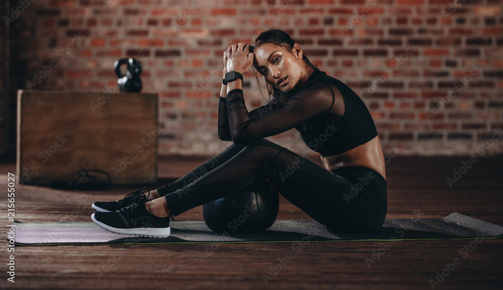 Fototapeta premium Kobieta odpoczynek po treningu crossowym na siłowni