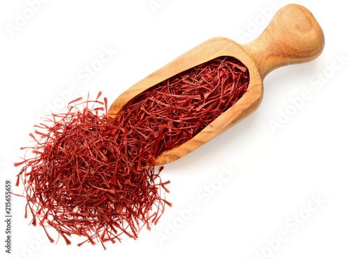 saffron thread in the wooden scoop, isolated on the white background, top view. photo