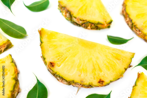 Sliced pineapple and green leaves pattern. Tropical pineapple summer fruit isolated on white background. Top view.