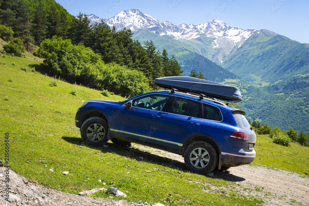 Car in mountains. Car is an off-road car in mountain on clear, sunny summer day. Travel by car through the wild. trip to the mountains by car. Amazing landscape of mountains in Svaneti, Georgia.