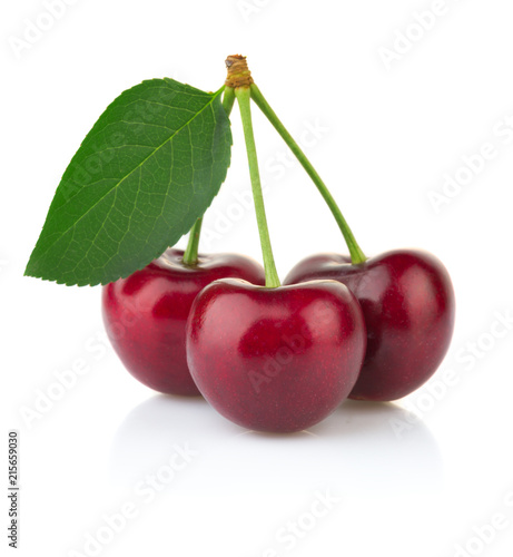 Ripe red cherry berries with green leaves isolated on white