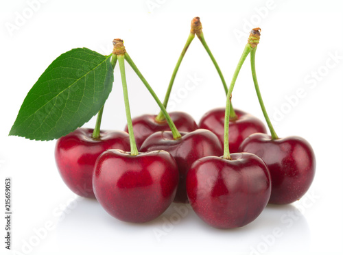 Ripe red cherry berries with green leaves isolated on white