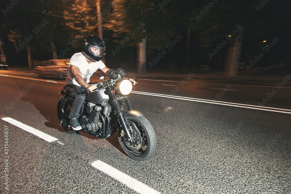 Fototapeta premium Rowerzysta jedzie nocą na motocyklu po autostradzie. Prędkość.