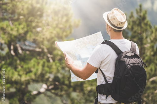 Photography Backpacker with the map on the top of the mountain