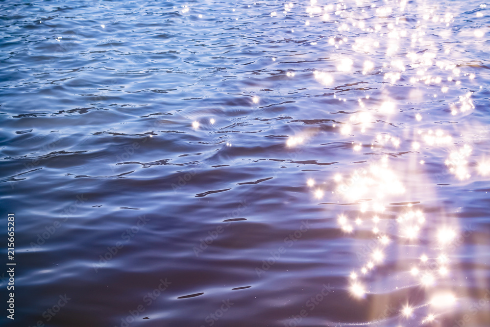 Sunlight twinkling off river water with small waves. Calm summer evening. Colorful background Sunlight twinkling off river water with small waves. Calm summer evening. Colorful background