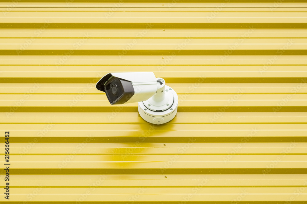 Fototapeta premium Surveillance video camera isolated on yellow