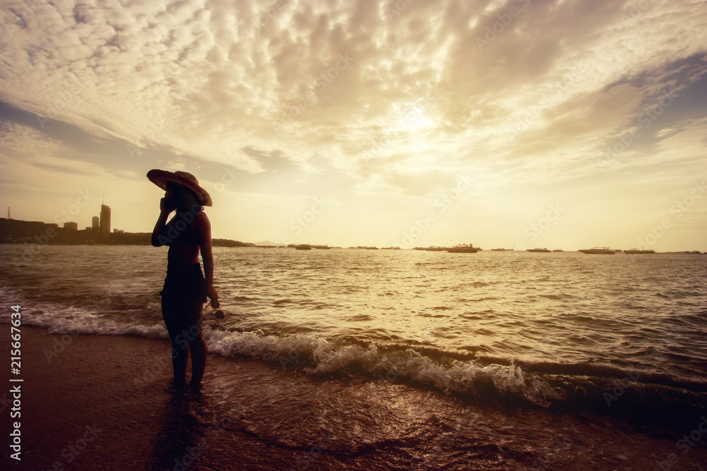 Silhouette Beautiful Asian woman in bikini  Call telephone at the sea 