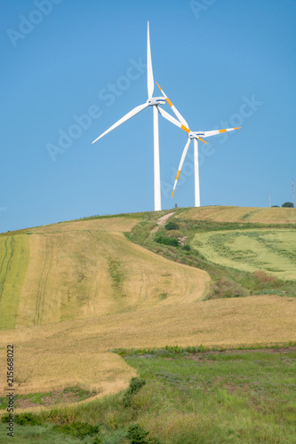 Modern wind farm with big wind turbines towers, source for renewable green energy