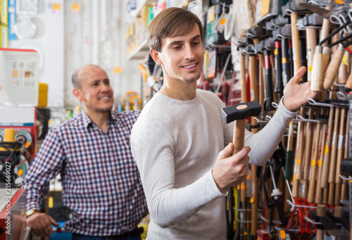 Customer choosing hammer in household store
