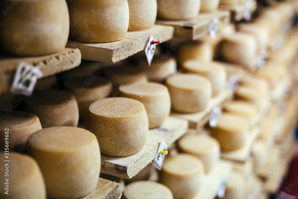 Cow milk cheese, stored in a wooden shelves Cow milk cheese, stored in a wooden shelves