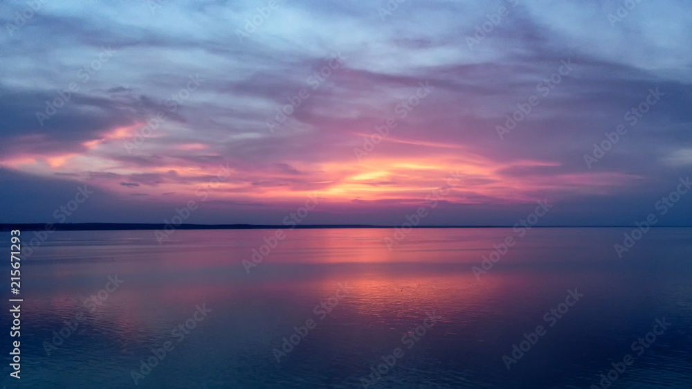 Fototapeta premium Piękny różowy zachód słońca z promieniami słońca nad morzem.