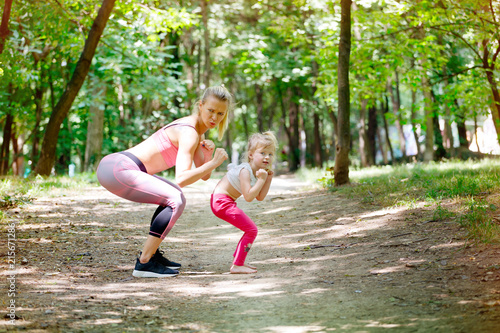 Boxing pose, ready to fight. Mother and daughter exercise together in park. Sport, Family, Healthy lifestyle © taramara78