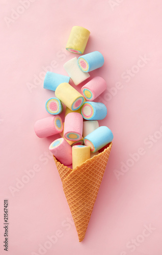Foto Marshmallow candy colorful assortment in an ice cream cone on a pink background viewed from above