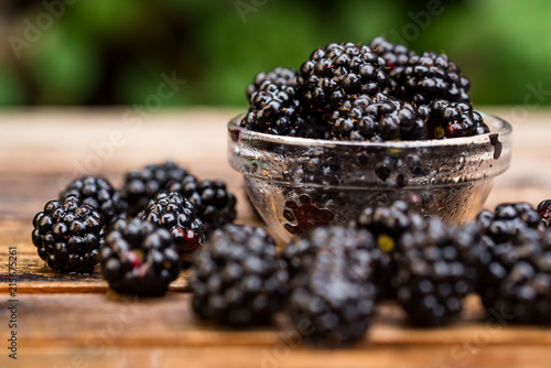 Fresh ripe blackberries in bowl on wooden table