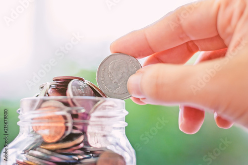 Hand saving a coin into the...