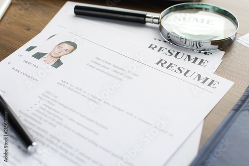 Resume  curriculum vitae  cv  and pen on a written wooden table. 