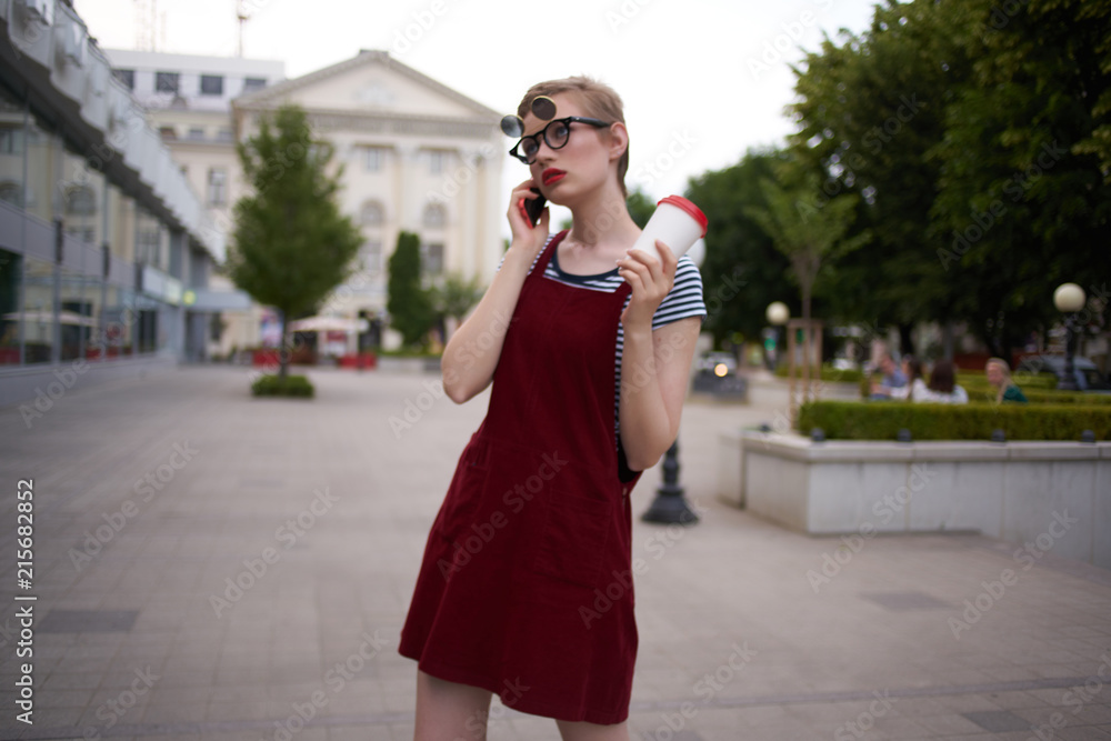 woman in glasses with coffee talking on the phone woman in glasses with coffee talking on the phone