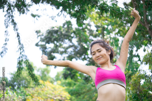 Asian sporty woman stretching arms breathing fresh air in the park,Thailand people exercise concept