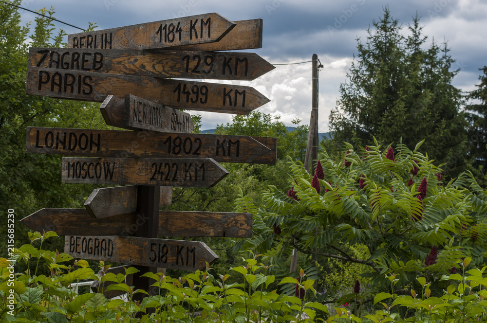 Foto Stock Croazia, 26/06/2018: cartelli stradali di legno con la distanza  dal centro storico di Drežnik, piccolo villaggio nella zona dei laghi di  Plitvice, alle principali capitali europee | Adobe Stock