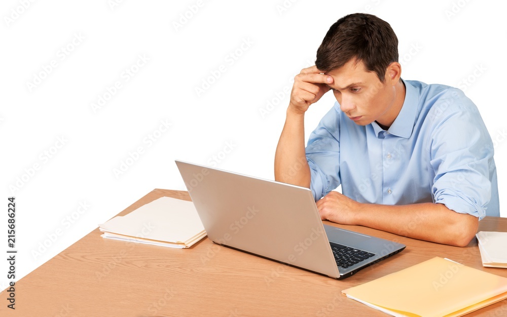 Tired young businessman with stack of papers and laptop Tired young businessman with stack of papers and laptop