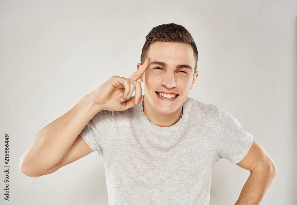 man smiling holds her finger at the head man smiling holds her finger at the head