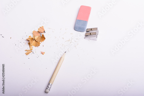 Pencil, rubber, sharpener and color pencils shavings isolated on white background