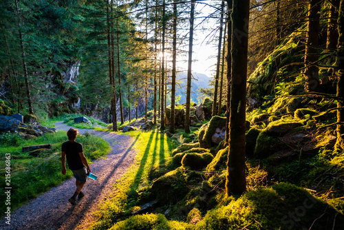 Guy hiking through a forest at sundown in Norway