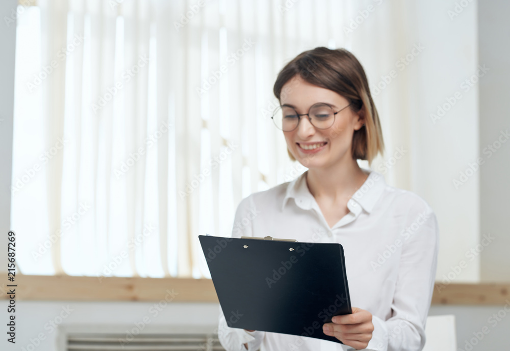 business woman with glasses smiling looks into the documents business woman with glasses smiling looks into the documents