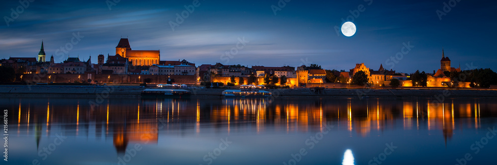 Old town reflected in river at sunset. Torun, Poland.