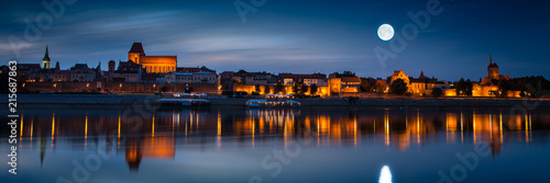 Old town reflected in river at sunset. Torun, Poland.