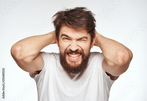 man with a beard is smiling holding hands behind his head