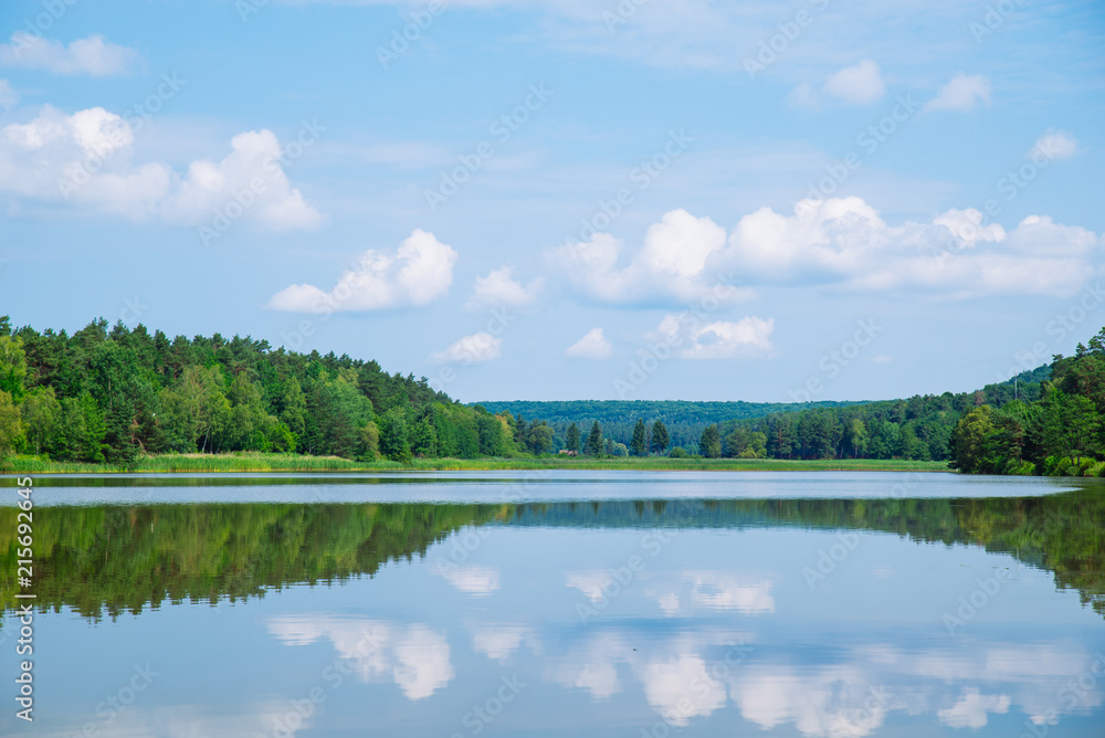 landscape view of lake in sunny summer day. sky reflection in water