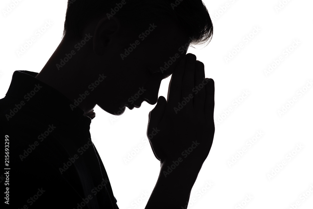 silhouette of praying young man on white isolated background