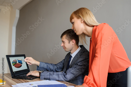 A business woman and man at a office desk working at the project