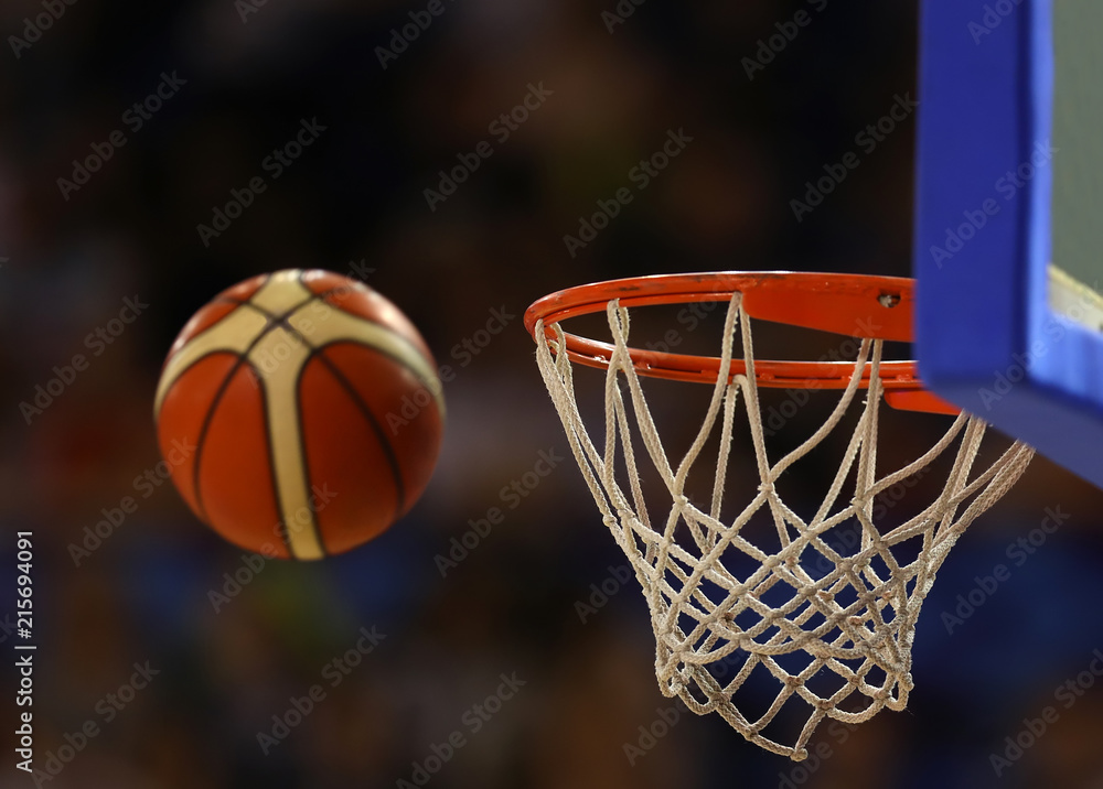 Basketball ball flies towards the basketball hoop on the background of the stands