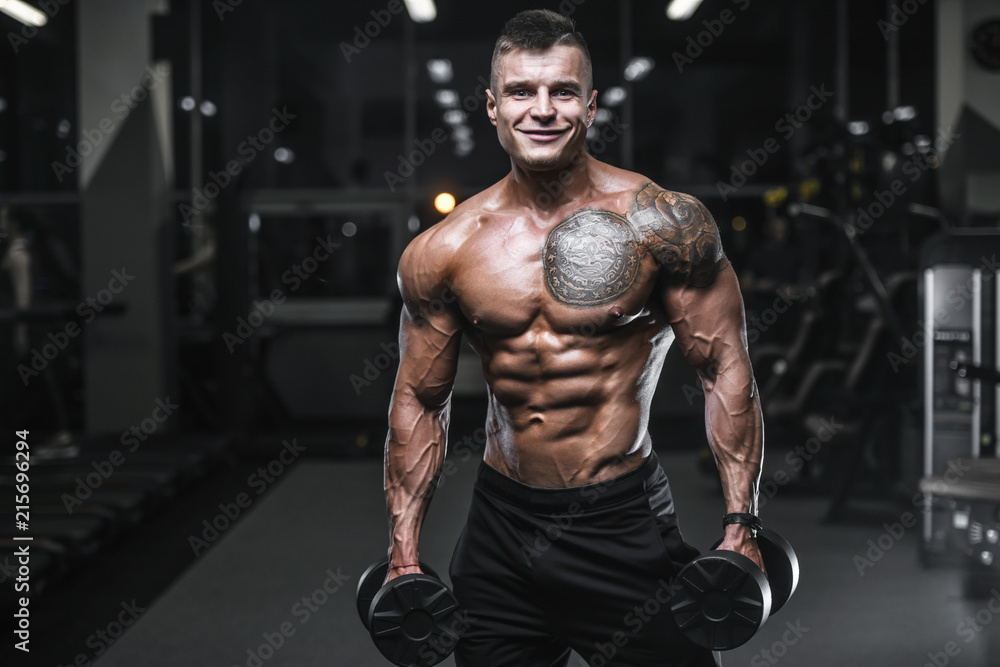 Handsome strong bodybuilder athletic men pumping up muscles with dumbbells Handsome strong bodybuilder athletic men pumping up muscles with dumbbells