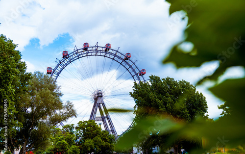 Ferris Wheel in Vienna Prater with green trees in foreground
