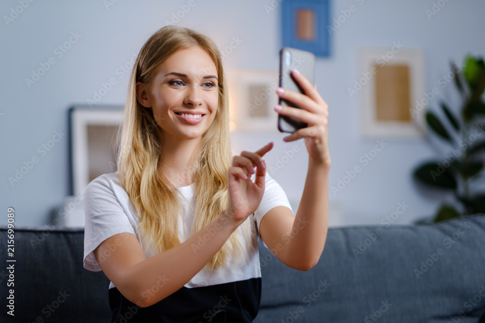 Beautiful woman using her smartphone in the living room Beautiful woman using her smartphone in the living room