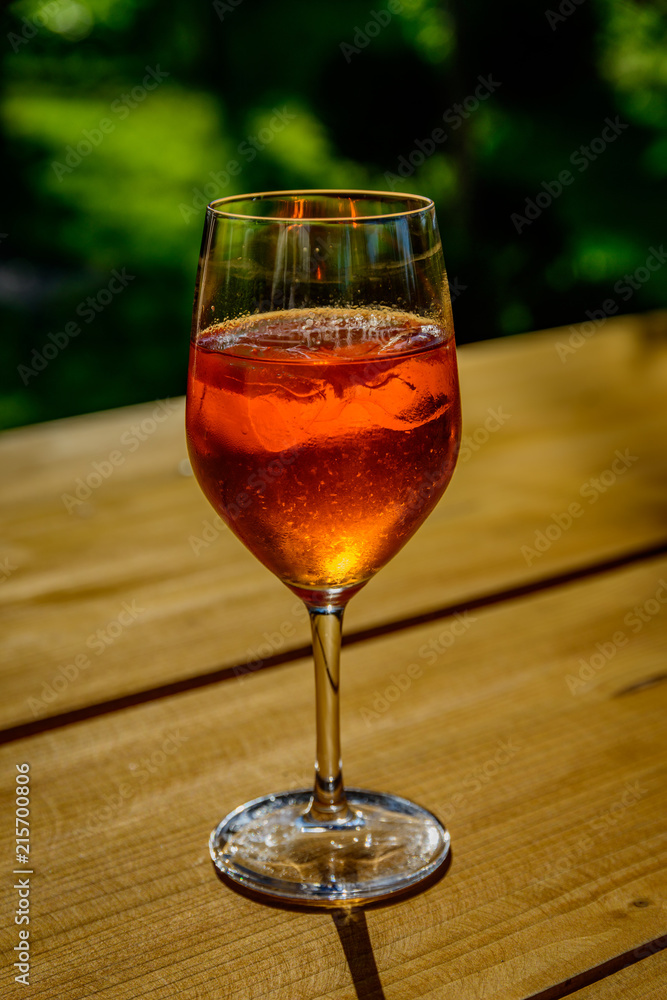 A glass of aperol spritz on a wooden table A glass of aperol spritz on a wooden table