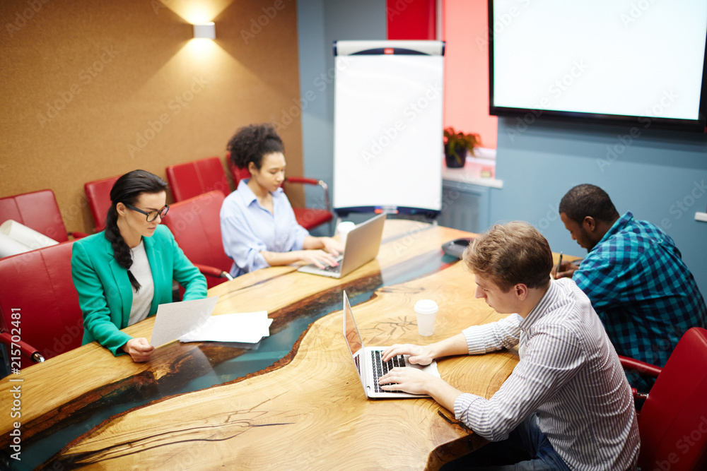 Young business people are busy while sitting at the table at boardroom Young business people are busy while sitting at the table at boardroom