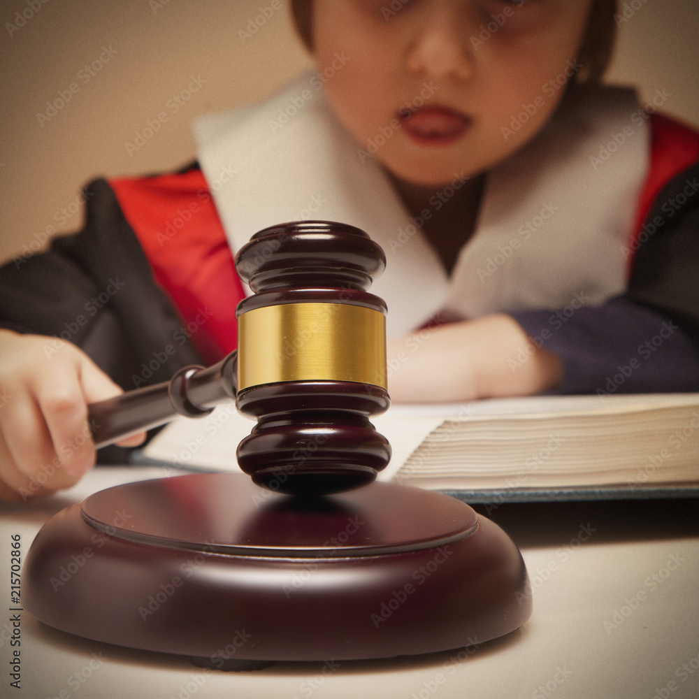 Portrait of serious child girl judge (lawyer) makes a decision. Humorous photo.(letter of law, strict law, justice concept) Portrait of serious child girl judge (lawyer) makes a decision. Humorous photo.(letter of law, strict law, justice concept)