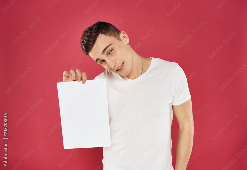 man holds empty white sheet on pink background man holds empty white sheet on pink background