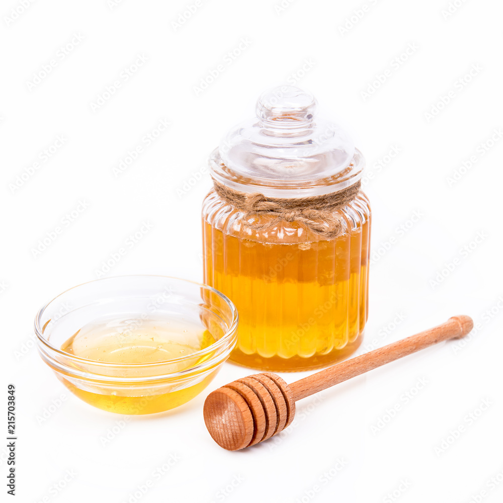 Isolated honey jar with honeycomb, honey dipper and glass saucer Isolated honey jar with honeycomb, honey dipper and glass saucer