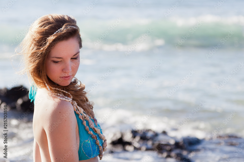Beautiful Young Woman at the Seashore Looking over Her Shoulder with Copy Space Beautiful Young Woman at the Seashore Looking over Her Shoulder with Copy Space