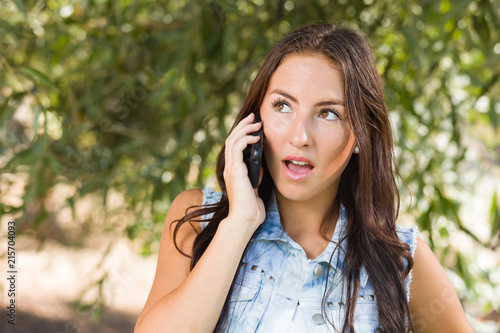 Unhappy Mixed Race Young Female Talking on Cell Phone Outside
