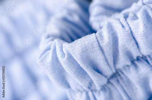 Blue fabric linen clothing seams rubber band on blur background