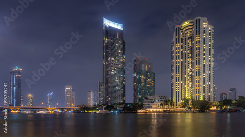 The bright lights of Bangkok's Silom financial district across the river at night