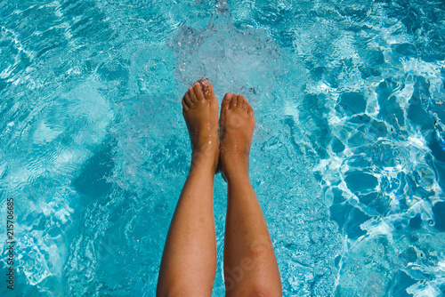 Female leg in the water in the pool, close-up. Vacation feeling concept.