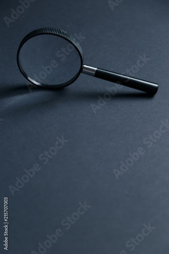 Magnifying glass on black texture background