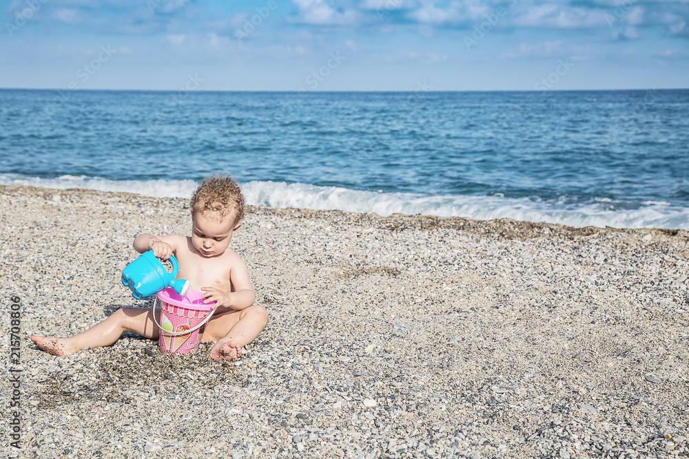 Lovely baby boy playing with beach toys Lovely baby boy playing with beach toys